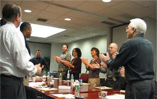People standing in room around table